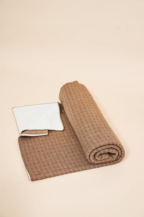 Toast self-heating knit throw blanket, rolled, showing the diamond knit and the FibreHeat back