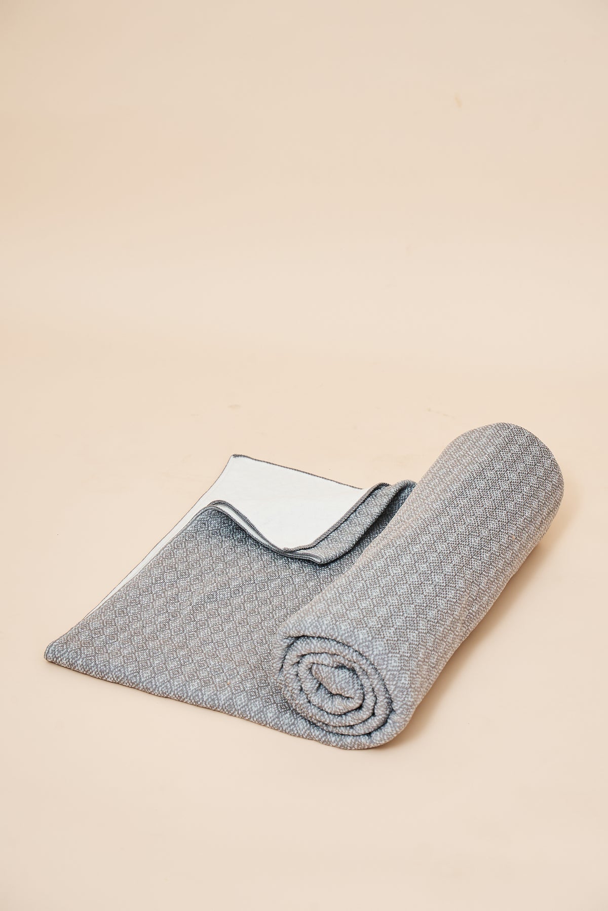 Slate self-heating knit throw blanket, rolled, showing the diamond knit and the FibreHeat back