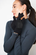 Woman in a dark top wearing black merino wool gloves with a self-heating liner and leather palm patch
