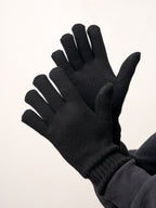 Black self-heating merino wool gloves with touchscreen fingertips, worn by a man