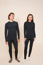Man and woman standing side by side in black FibreHeat base layer shirts and leggings