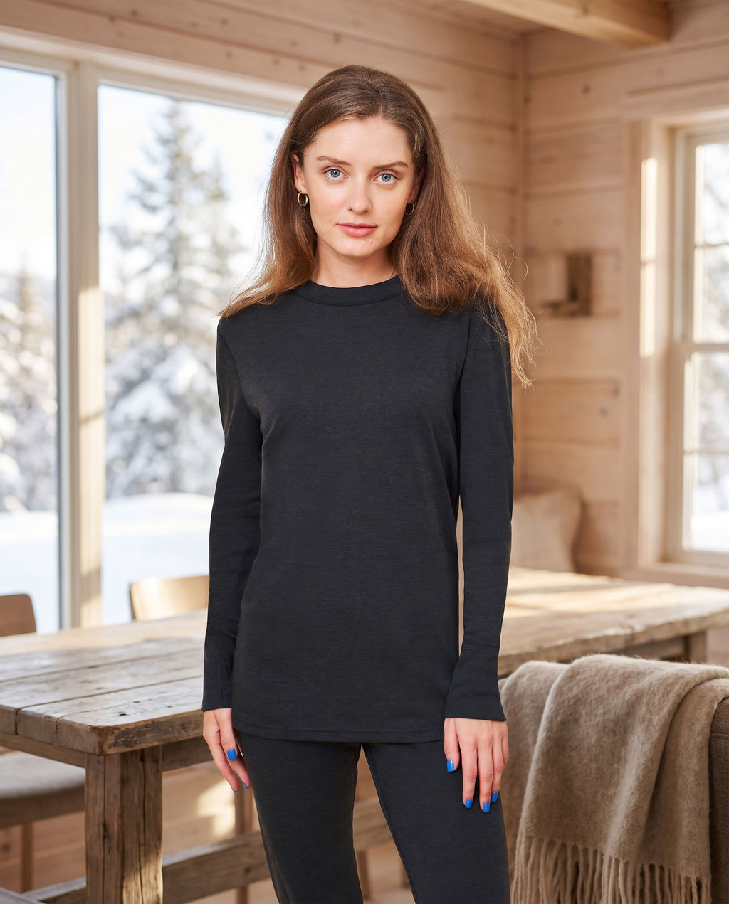 Woman wearing the black FibreHeat base layer shirt in a bright cabin