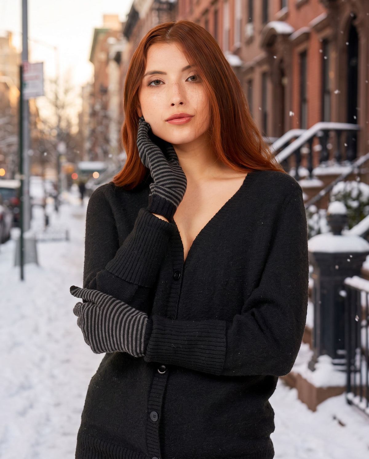 Woman wearing striped FibreHeat merino gloves on a snowy city street