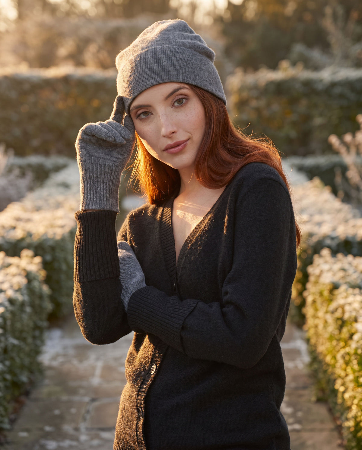 Woman wearing Grey Heather FibreHeat cashmere gloves in a winter garden