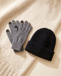 The Warm-Up Bundle: gray heather cashmere gloves and black knit beanie on a cream knit throw
