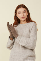 Woman in a grey sweater wearing Brown Sugar Melange self-heating merino wool gloves