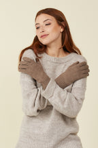 Woman in a grey sweater with arms crossed, wearing Brown Sugar Melange self-heating merino wool gloves