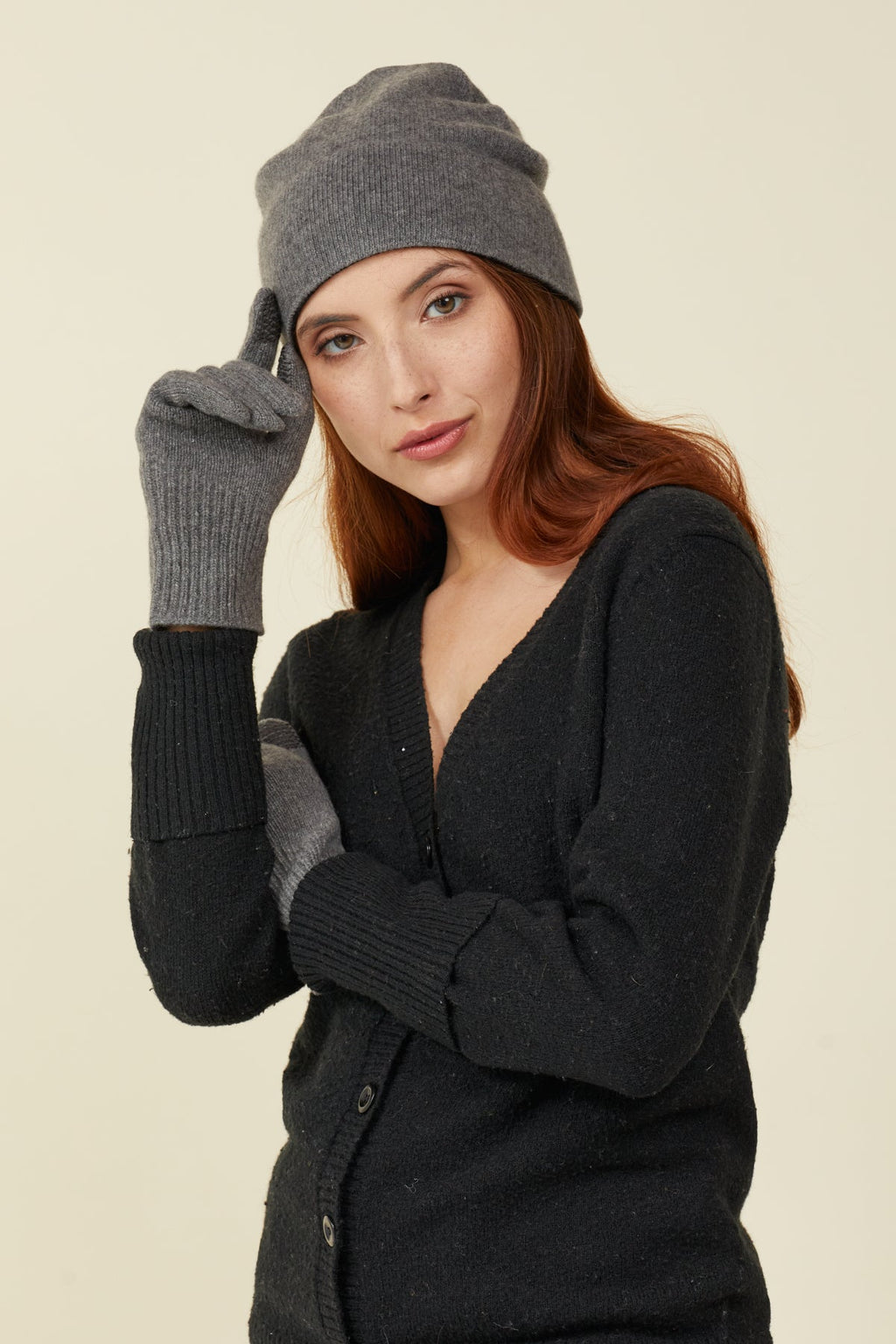 Woman in a grey beanie wearing Grey Heather cashmere gloves with self-heating liners