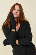 Woman in a black cardigan wearing black wool blend flip top mittens