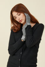 Woman in a black cardigan wearing Charcoal Twist Ultra Liners, hand resting on her face